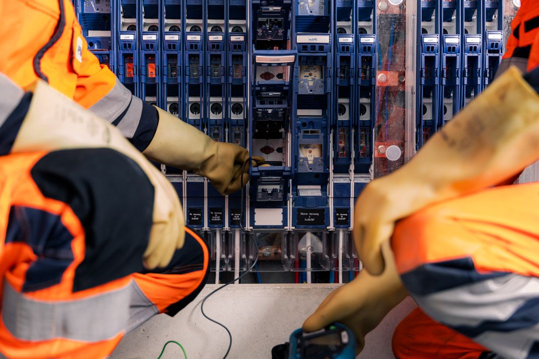 Firmenfotografie Evolon AG: Netzelektriker mit Schutzhandschuhen am Verteilerschrank
