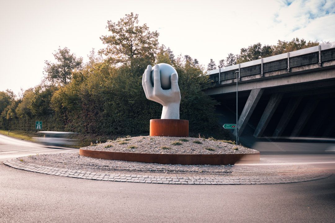 Kreiselskulptur Lyss: Hand mit 250 kg schwerer Chromstahlkugel von SKULTUR und Bottinelli Sculpt, Kunst am Bau im Seeland fotografiert